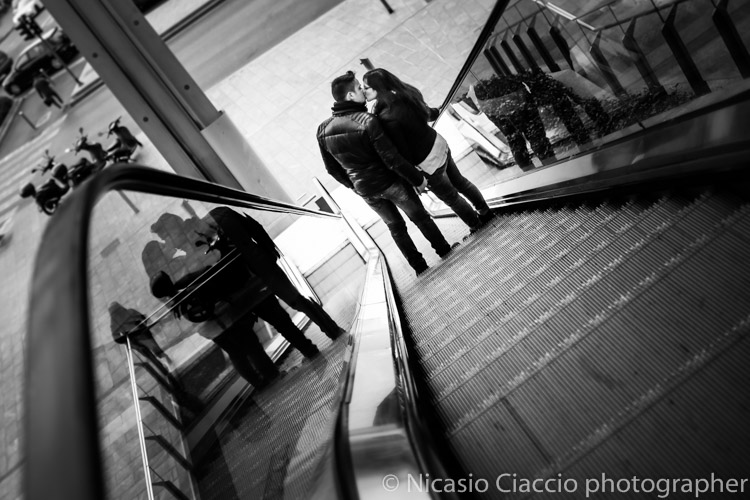 bacio fotografia coppia di innamorati scale mobili piazza Gae Aulenti di milano